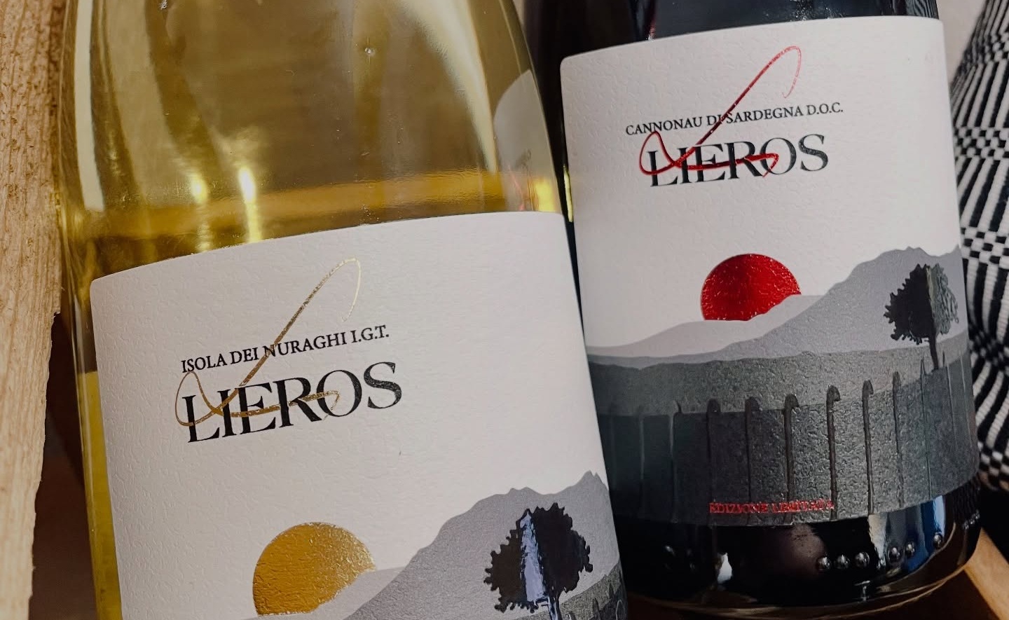 Due bottiglie Lieros, Isola dei Nuraghi IGT bianco e Cannonau di Sardegna DOC, etichette con sole oro e rosso